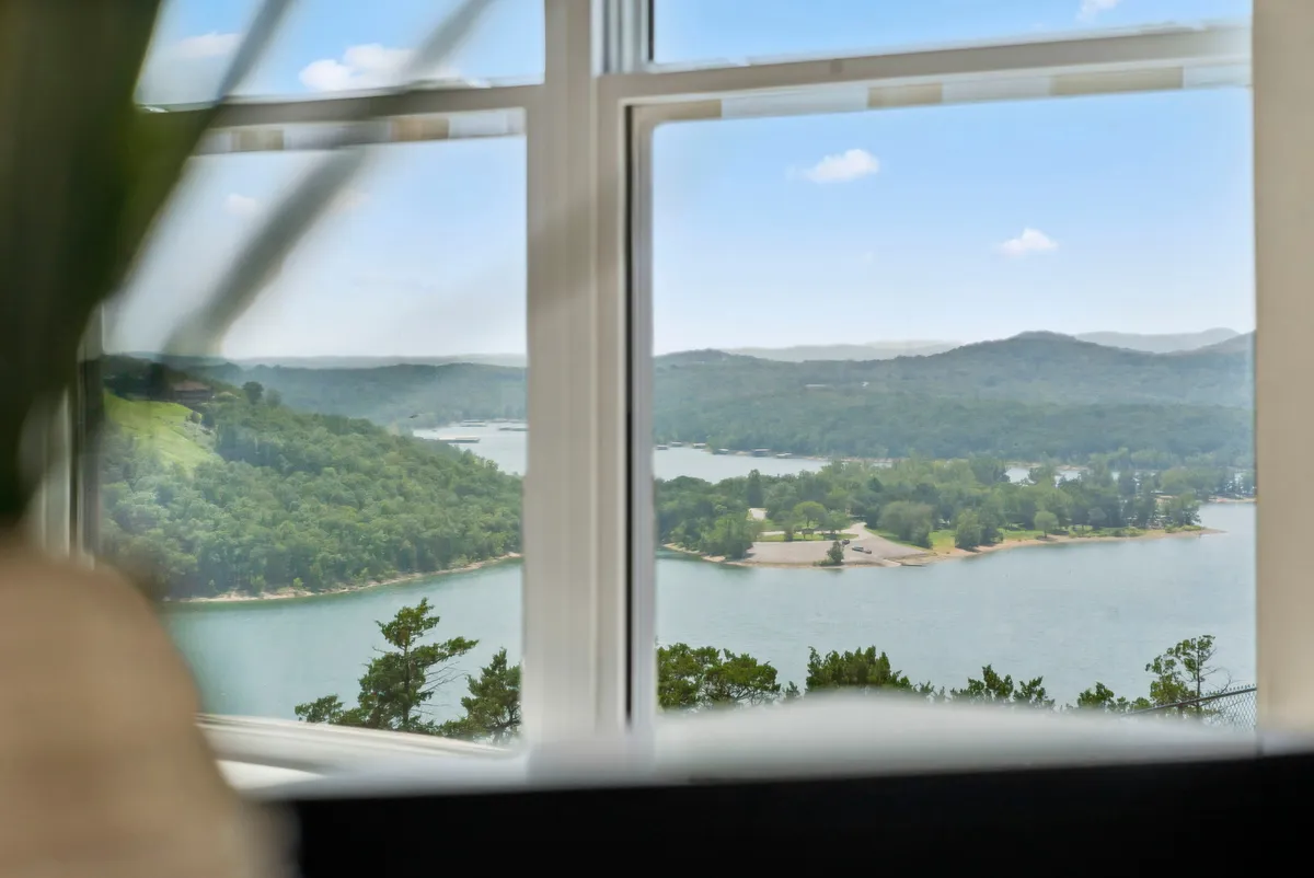 A serene, wide-angle lake view with calm waters, distant hills, and trees along the shoreline, capturing the tranquil beauty of Table Rock Lake at sunset or sunrise.