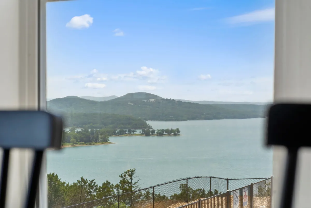 A sweeping view of the lake, distant hills, and surrounding trees under a vast sky. The expansive scenery evokes a deep sense of peace and connection to the outdoors, perfect for nature walks and mindful escapes.